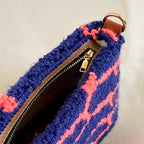 Close-up detail of Pochette Lido punch needle DIY bag with zipper finish.