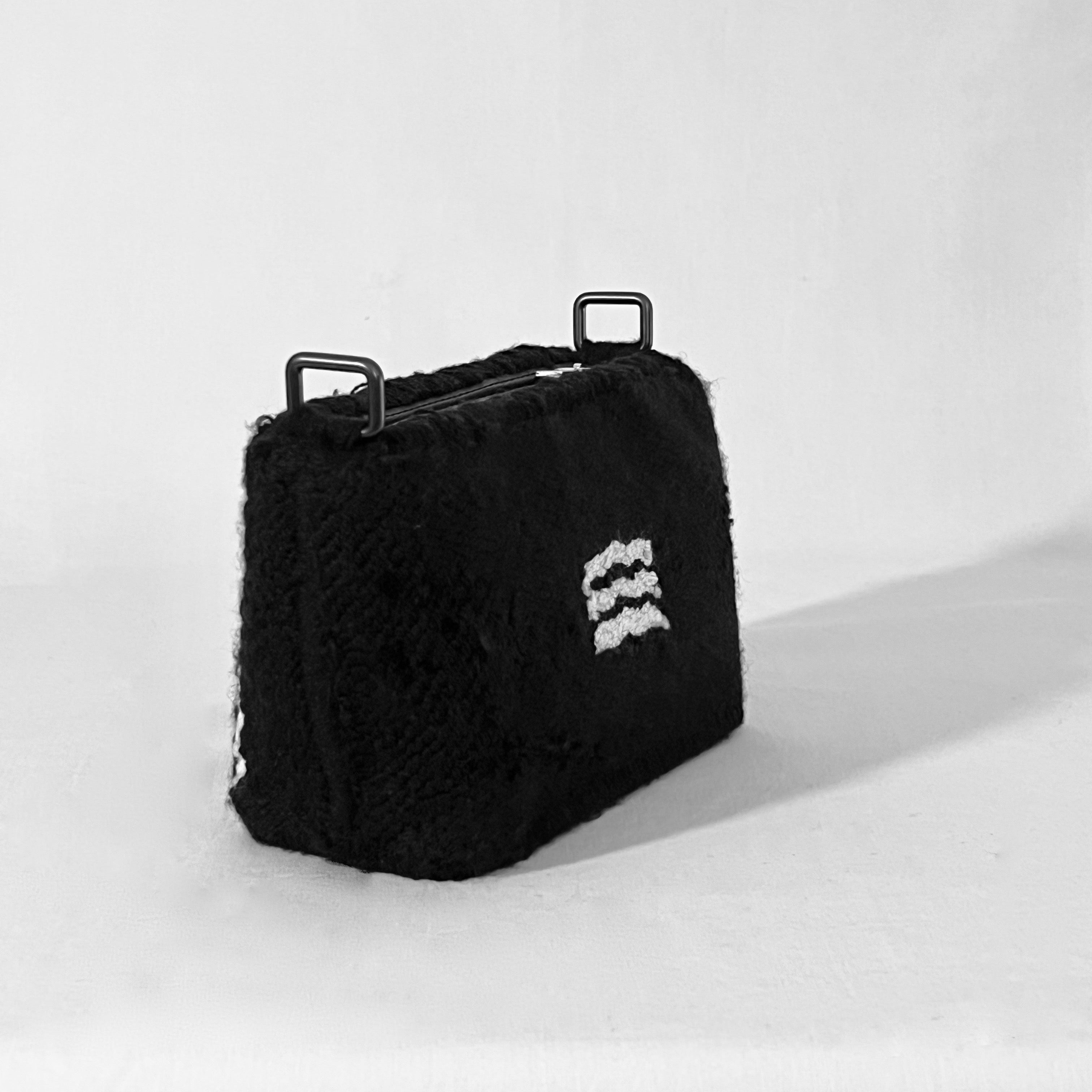 Side view of handmade Ohpunch Pochette Water Cipher punch needle bag showing structured shape.