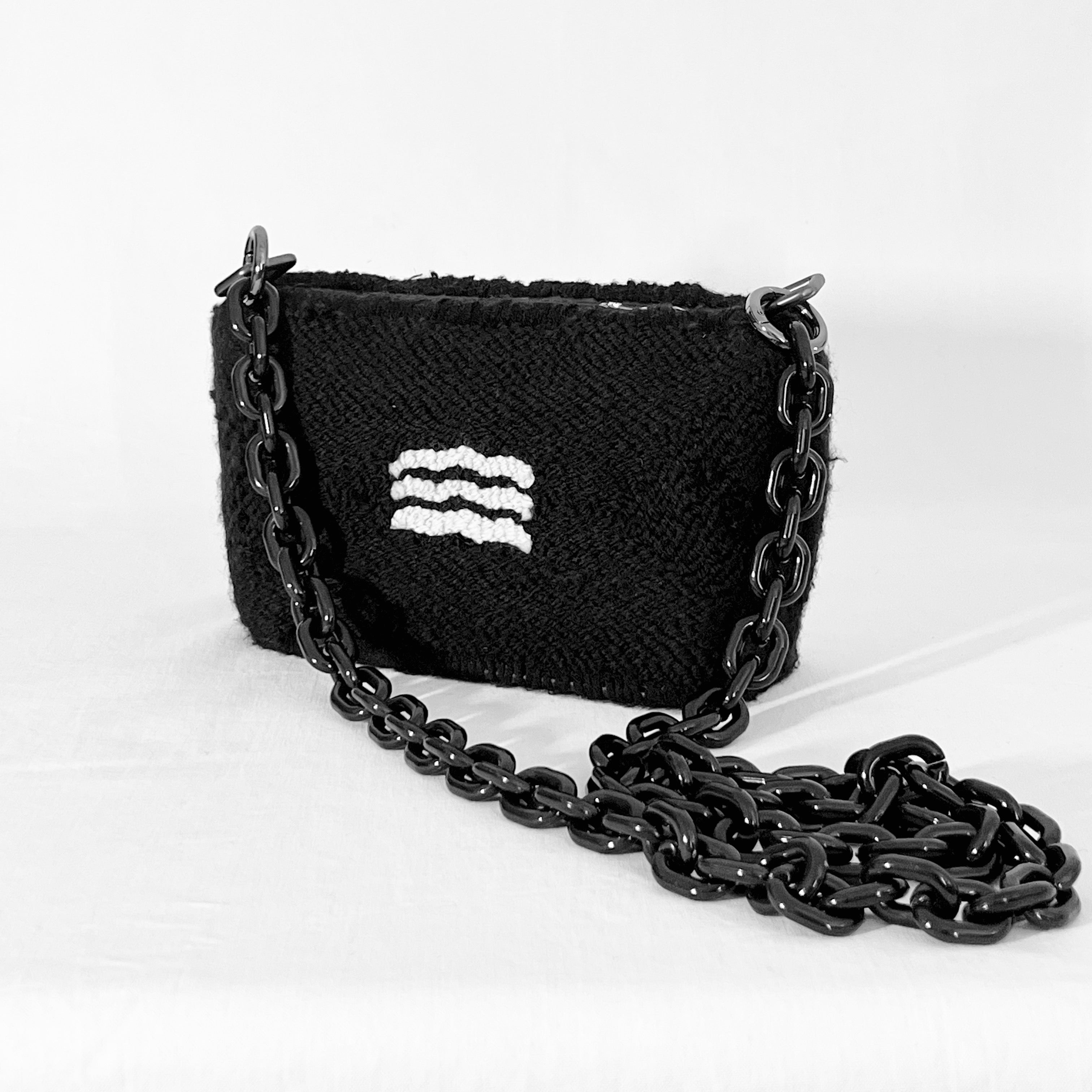 Side view of Ohpunch Pochette Water Cipher punch needle DIY bag with detachable black chain strap.