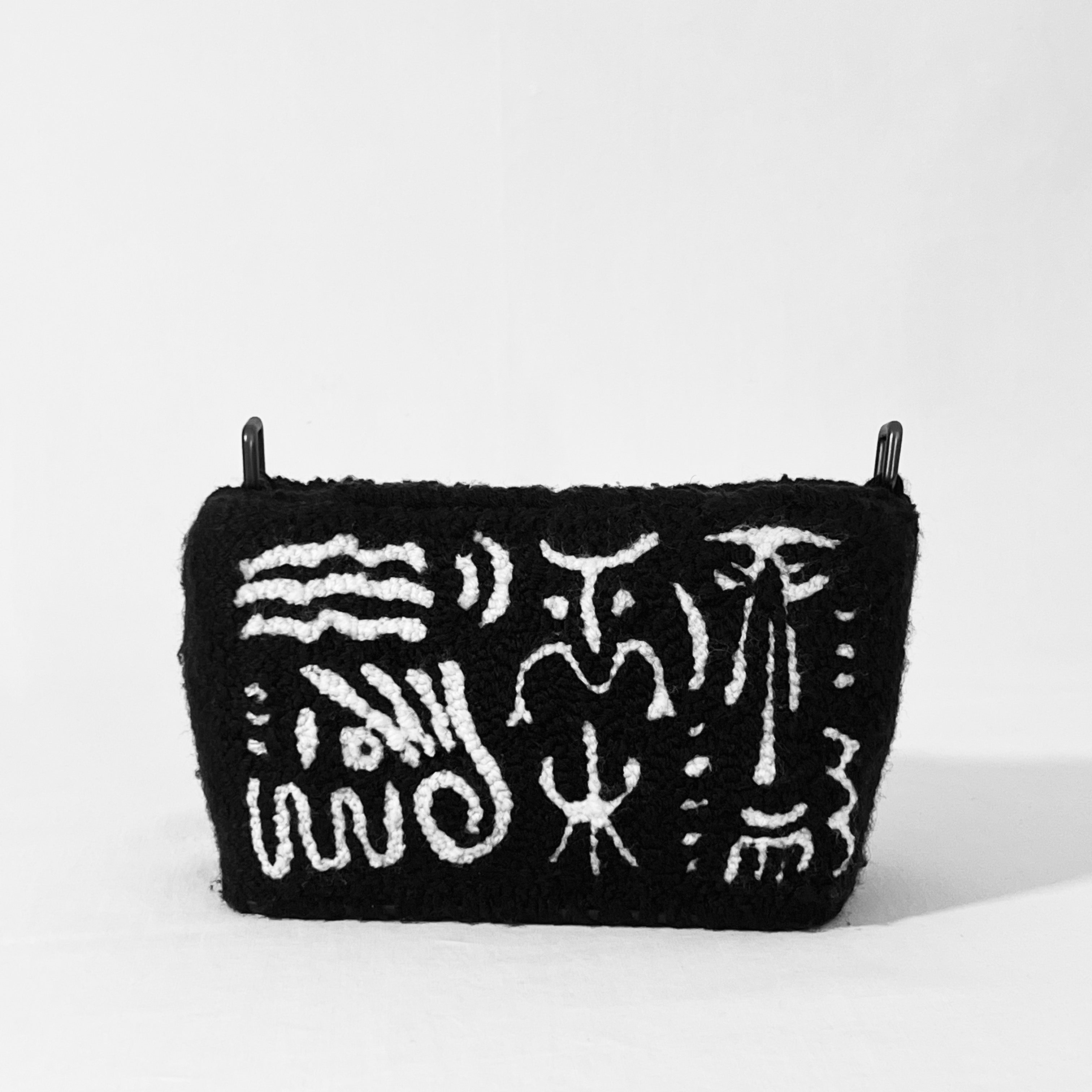 Front view of Ohpunch Pochette Water Cipher punch needle DIY bag with black and white symbolic pattern